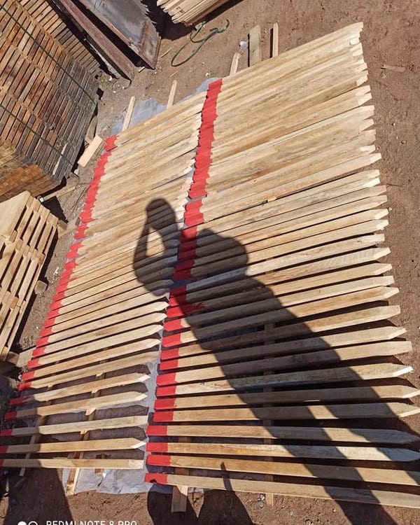 Estacas de madera con cabeza pintada de rojo, en palé