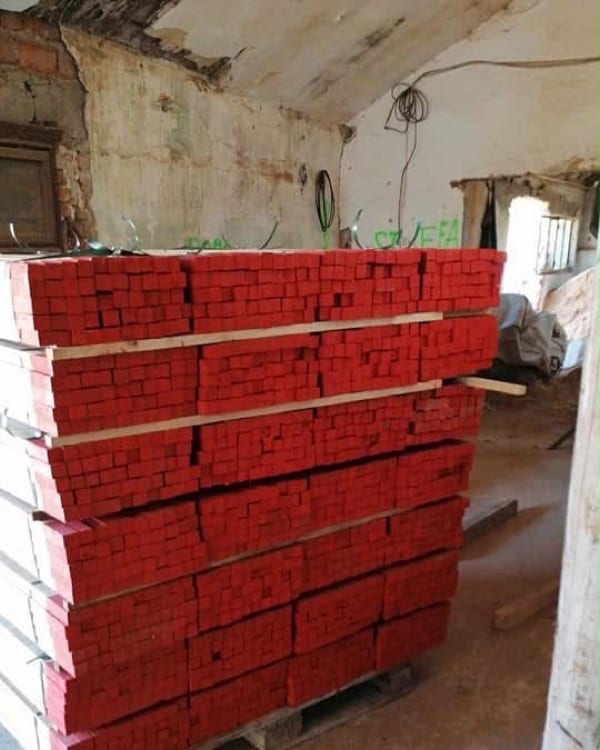 Estacas de madera con cabeza pintada de rojo, en palé